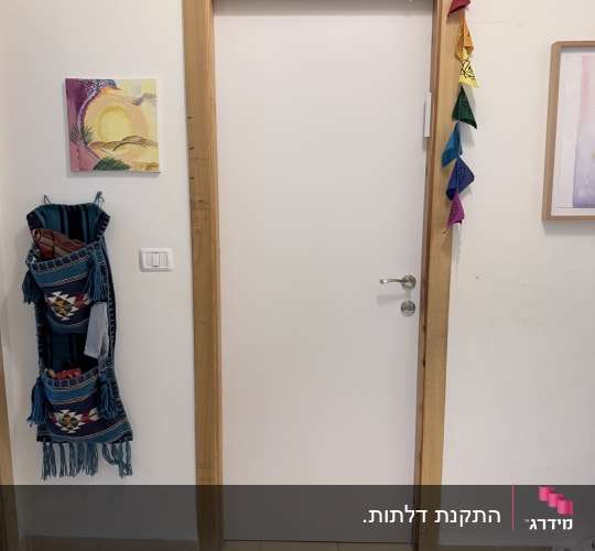 דלת לבנה עם מסגרת עץ וקישוטים צבעוניים